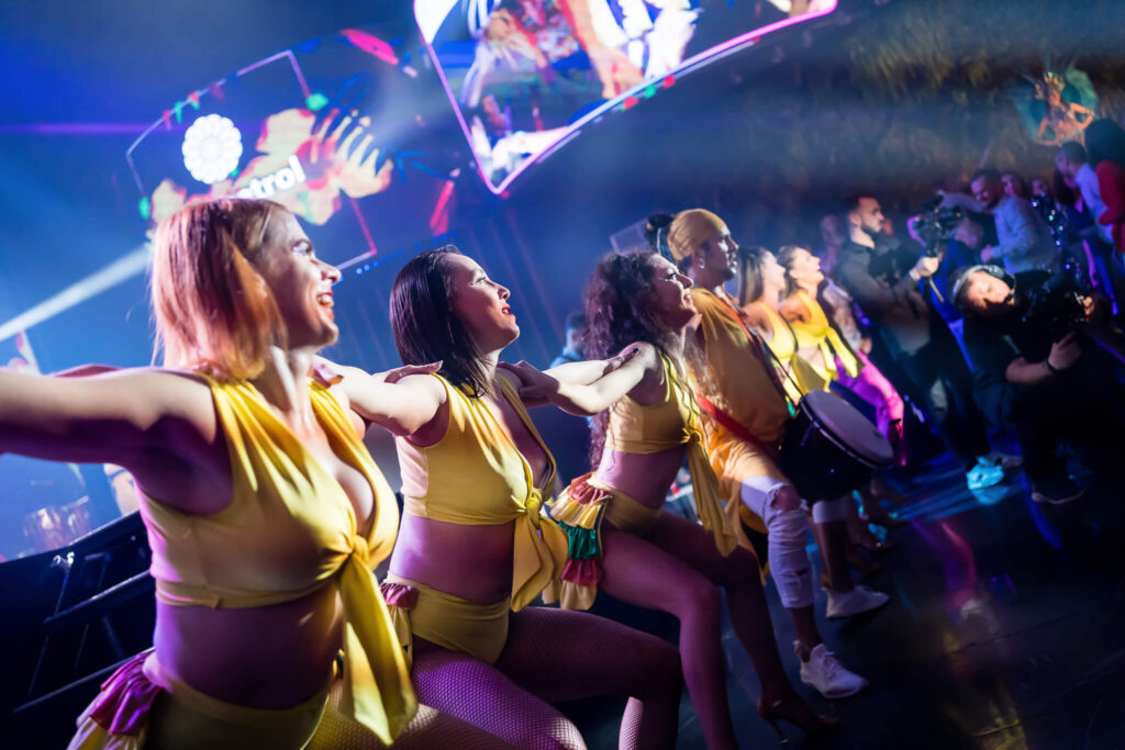 Dansatoare in costume galbene la workshop de dans latin Wilmark cu scenă și iluminare